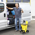 man with bucket outside a van