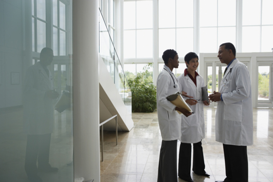 picture of 3 doctors talking in atrium in white lab coats