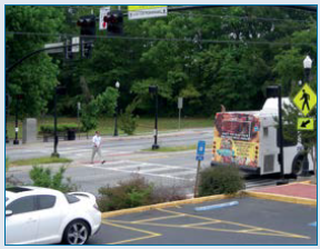 Figure 6. PHB protects pedestrians crossing Buford Highway. Person crossing a four lane street via a crosswalk with its own red light signal
