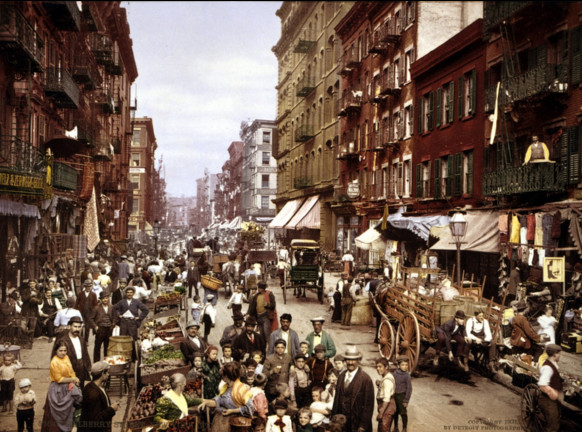 photo of many people, vendors, horse carts, etc. in city street