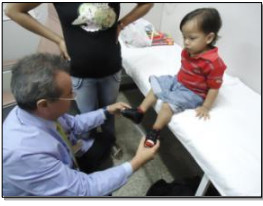 image of doctor with hands on feet of young patient