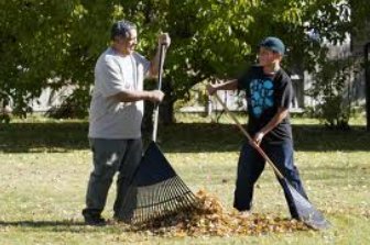photo or two people raking leaves together