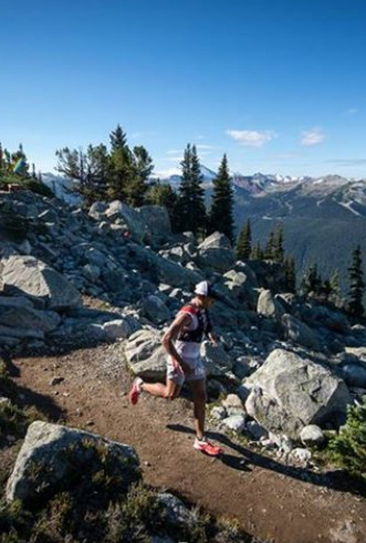 ultramarathon runner on downhill trail among boulders