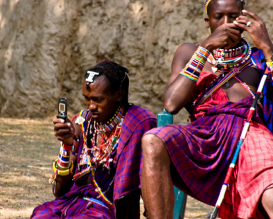 image of two tribesmen in native dress using mobile telephones