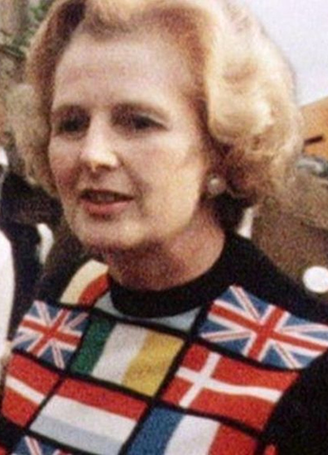 photo of Margaret Thatcher wearing a sweater bearing a dozen or more national flags