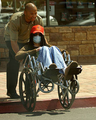 photo of someone famous being rolled in a wheelchair