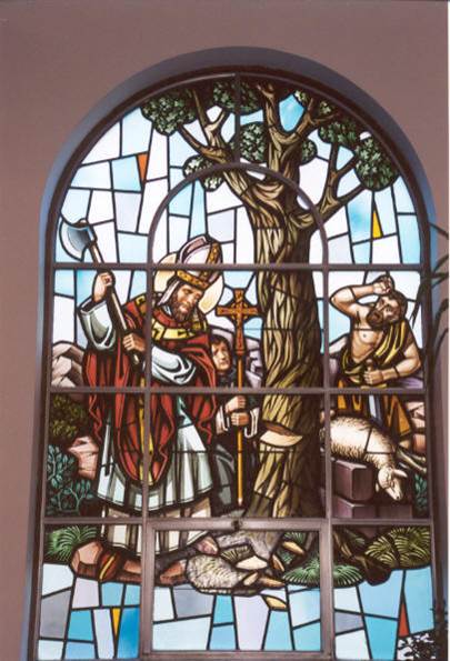 image in stained glass window of St. Boniface chopping at a tree