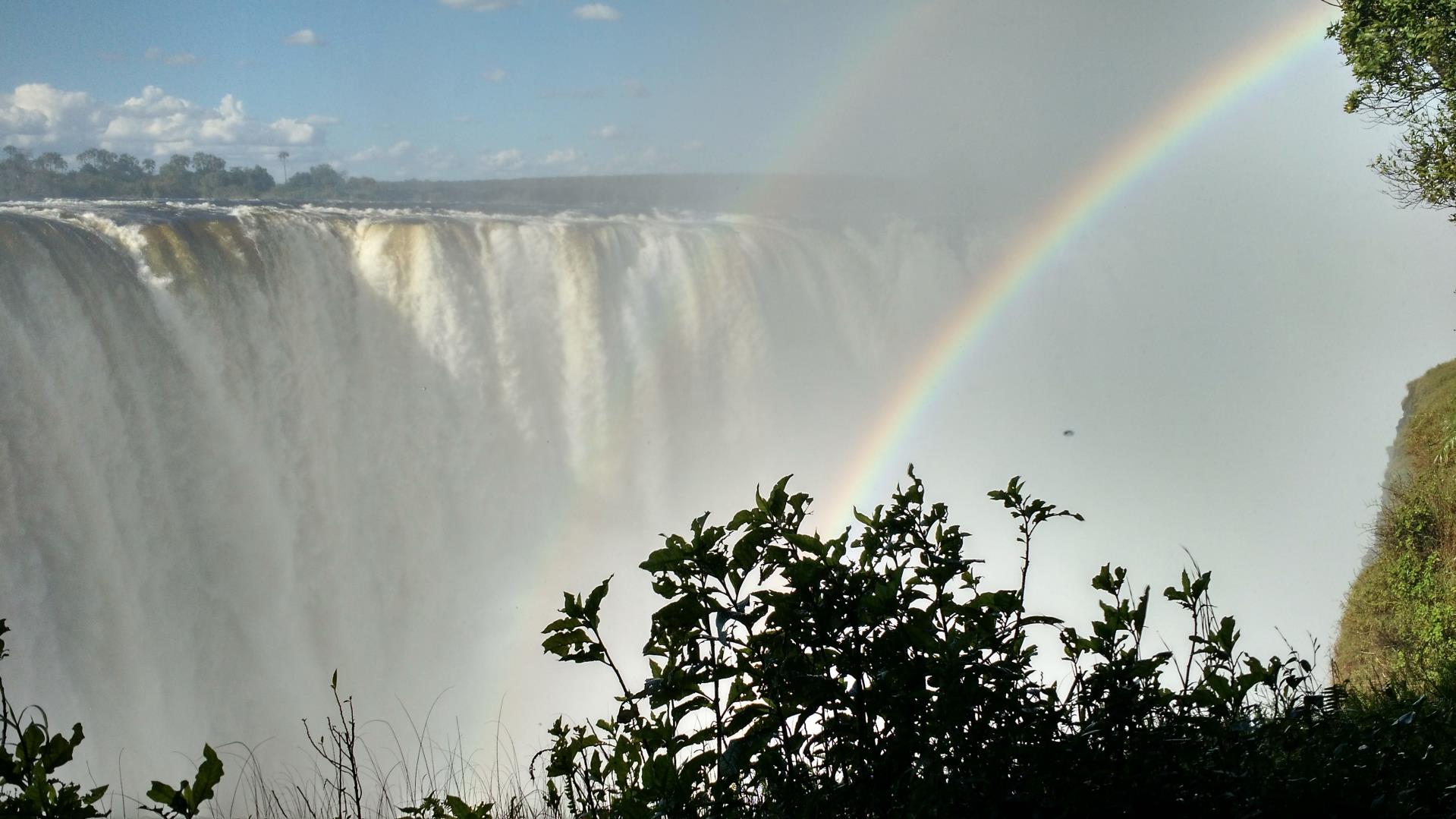 photo of a rainbow in front of Victoria Falls