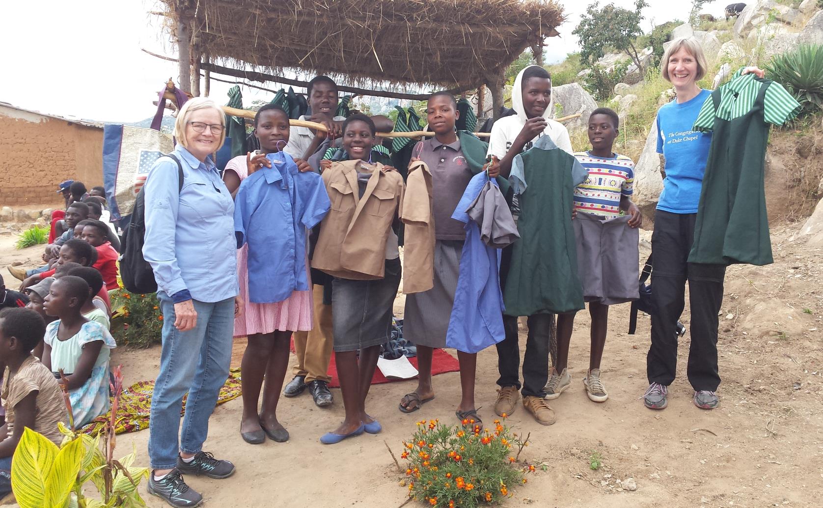 photo of teenagers holding uniforms