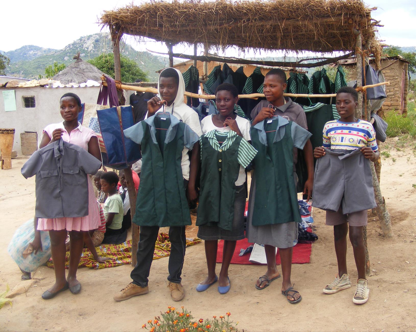 photo of teenagers holding uniforms
