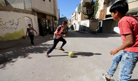 Palestinian children play soccer in the streets of Jenin refugee camp in the northern West Bank