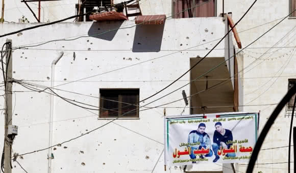 Damage from bullets and fragments cover the walls of a Palestinian house in Jenin refugee camp, West Bank