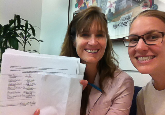 UTLA teachers Megan Markevich and Marisa Crabtree hold petitions for online voting in their teachers union
