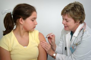 Nurse giving a young girl a vaccine