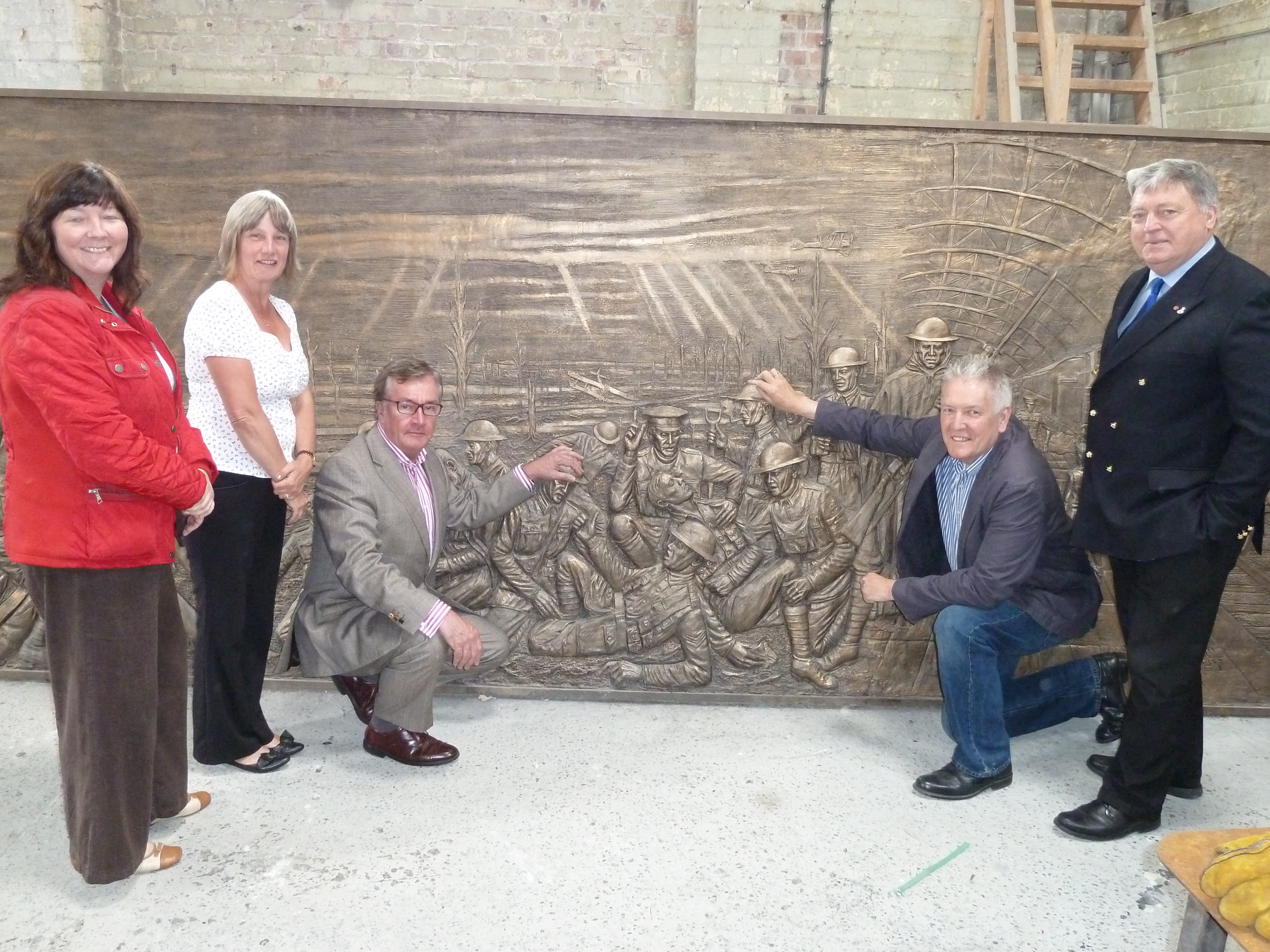 Sculptor Tom Murphy and Liverpool Pals Memorial Fund chairman Lt Col (retd) Anthony Hollingsworth gives a sneak preview of the frieze to Maghull Town Council Labour leader Cllr Patrick McKinley, Maghull Town Council World War I commemoration committee chairwoman Cllr June Burns and town council clerk Angela McIntyre.