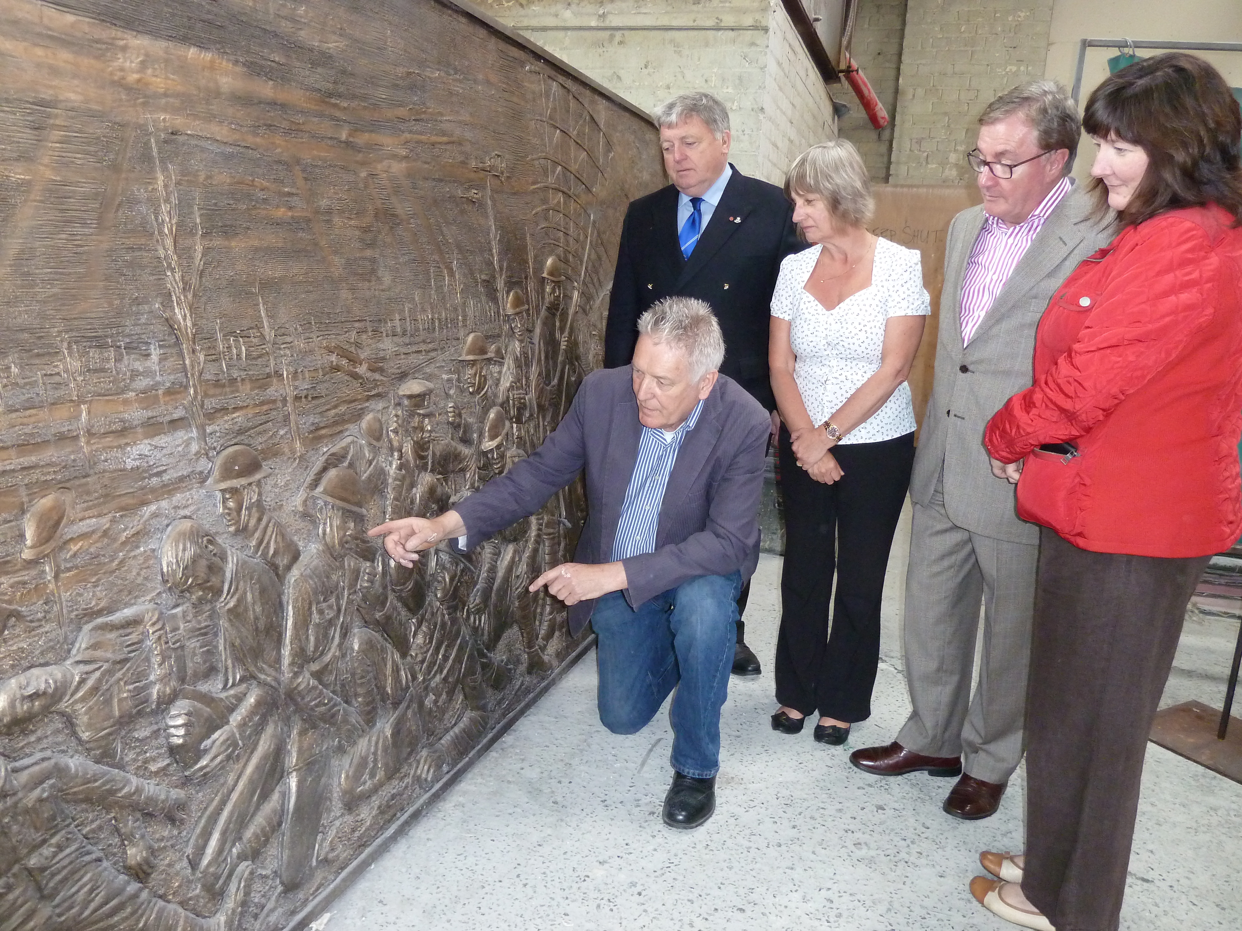 Sculptor Tom Murphy and Liverpool Pals Memorial Fund chairman Lt Col (retd) Anthony Hollingsworth gives a sneak preview of the frieze to Maghull Town Council Labour leader Cllr Patrick McKinley, Maghull Town Council World War I commemoration committee chairwoman Cllr June Burns and town council clerk Angela McIntyre.