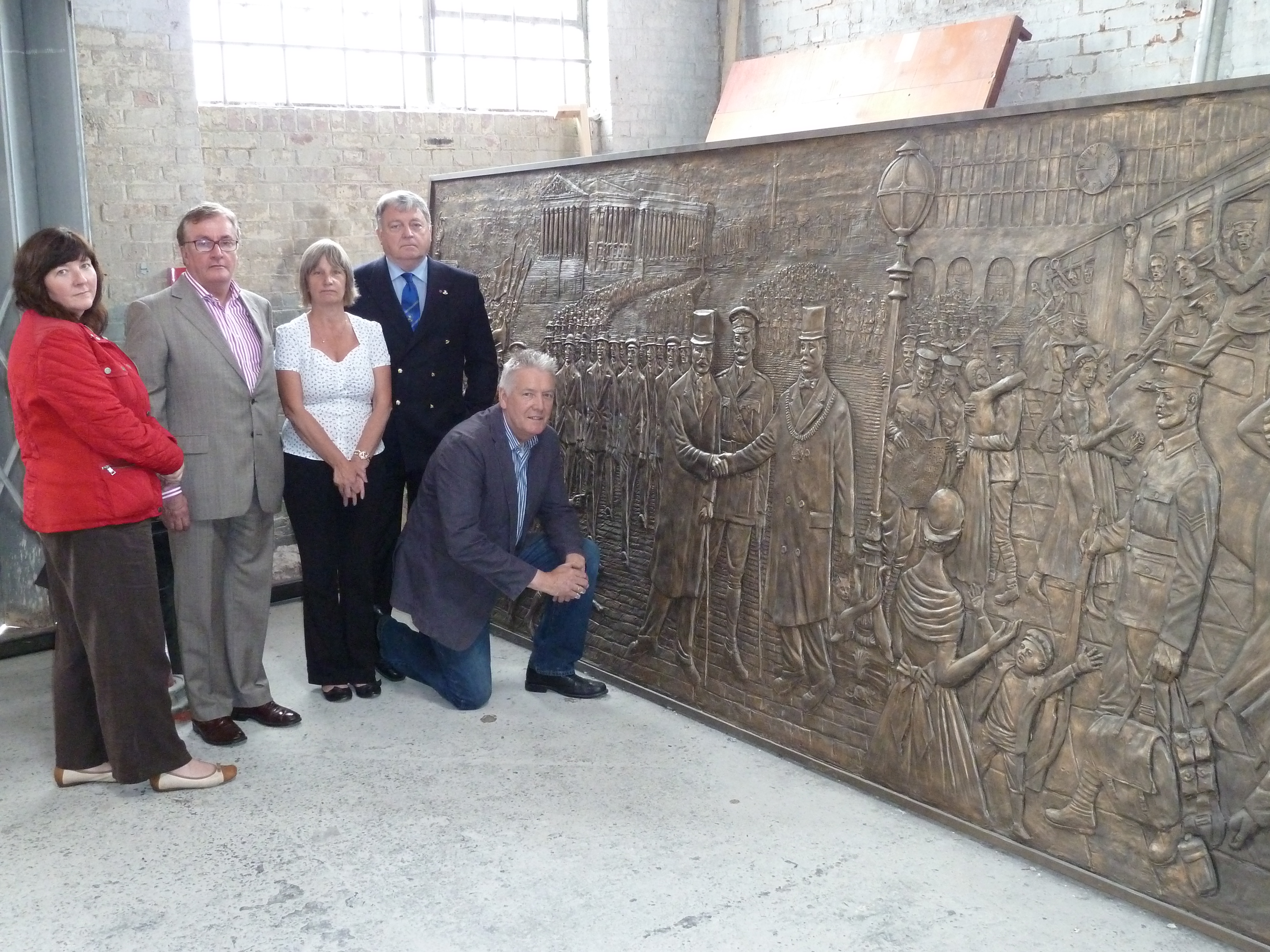 Sculptor Tom Murphy and Liverpool Pals Memorial Fund chairman Lt Col (retd) Anthony Hollingsworth gives a sneak preview of the frieze to Maghull Town Council Labour leader Cllr Patrick McKinley, Maghull Town Council World War I commemoration committee chairwoman Cllr June Burns and town council clerk Angela McIntyre.