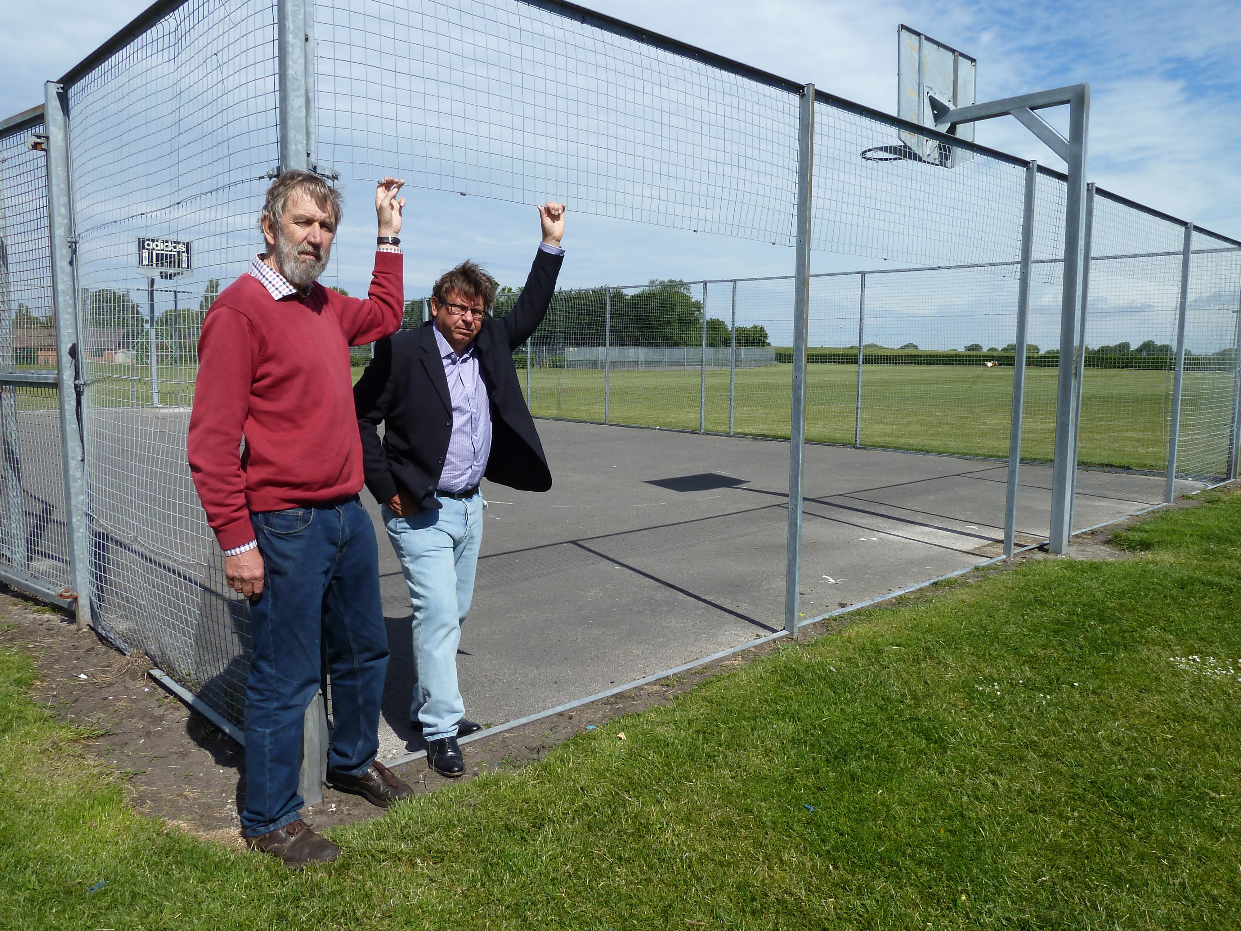 Lydiate Parish Council chairman Cllr John Bailey and vice chairman Cllr Andy Wilson at the Sandy Lane basketball court where sections of the fencing was also stolen