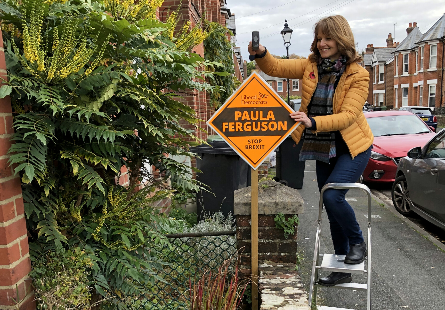 Paula putting up a garden poster