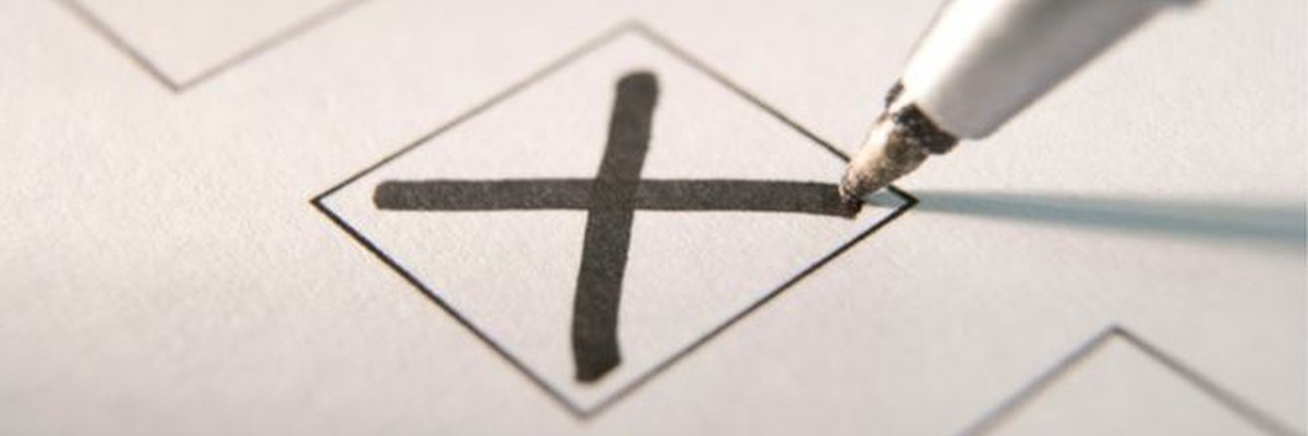 A pen marking an X in a box.