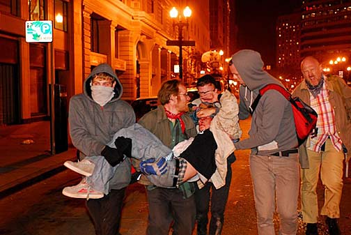 Scott Olsen, a former U.S. Marine and veteran of two tours in the Iraq war, is carred away by fellow Occupy Oakland protesters after being shot in the head by a police projectile on the night of October 25, 2011. (Credit: REUTERS/Jay Finneburgh/www.indybay.org)