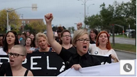 des femmes dans en action la rue avec une bannière, les poings levés, scandant des slogans