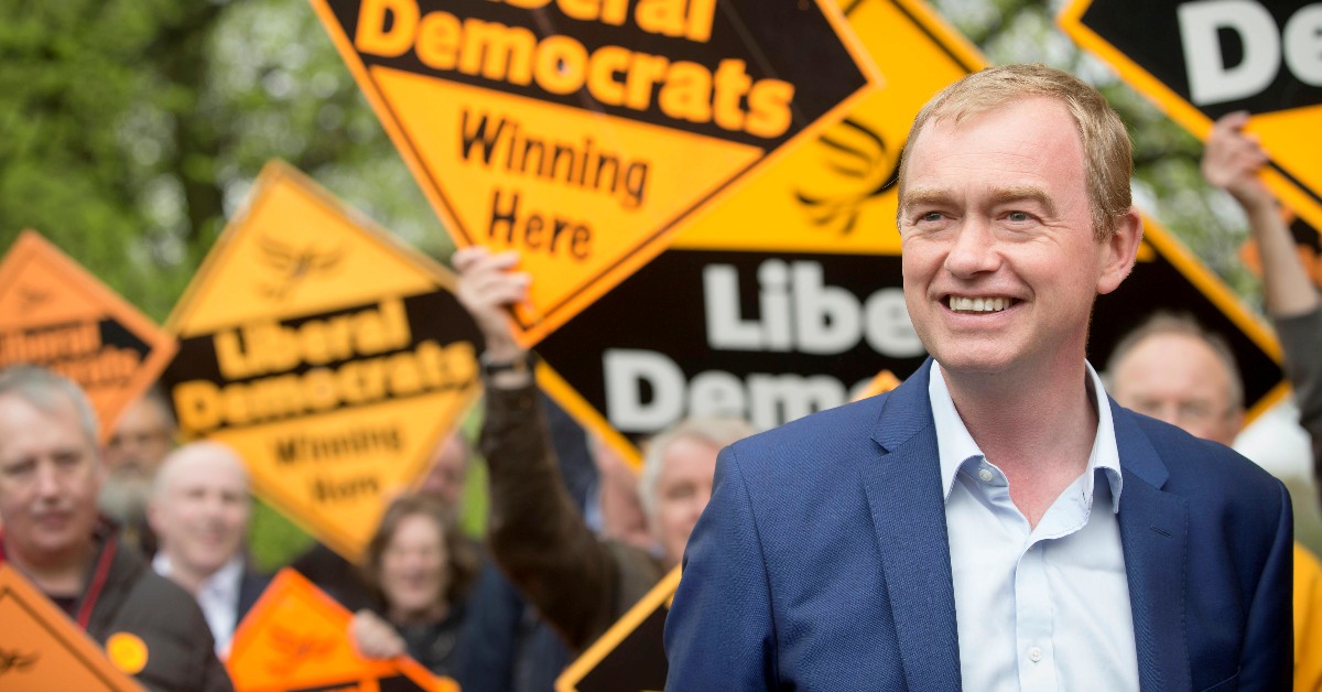 Tim Farron in front of activists holding Lib Dem diamonds.