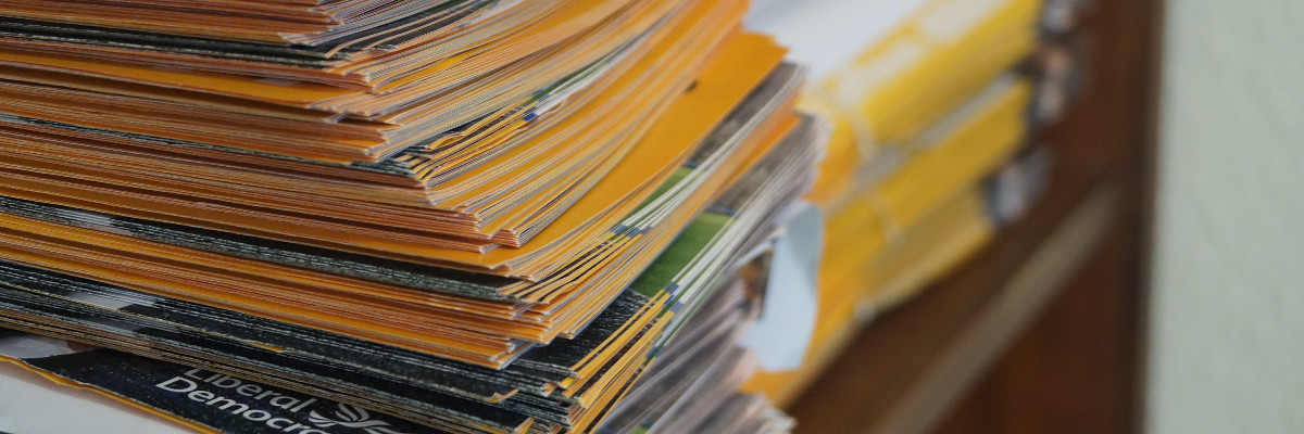 A pile of leaflets to be delivered in a Liberal Democrat Office