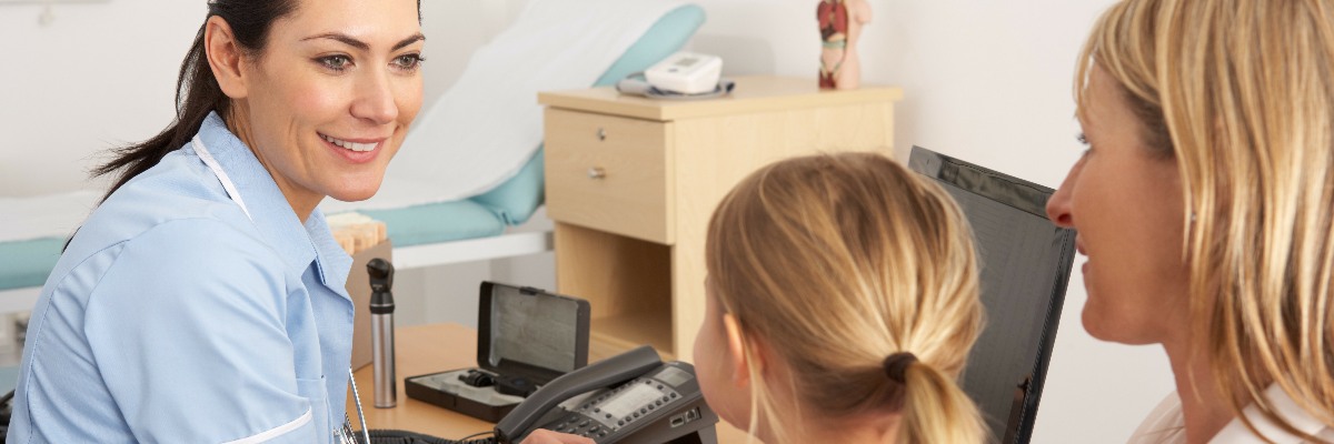 A nurse talking to a woman and child.
