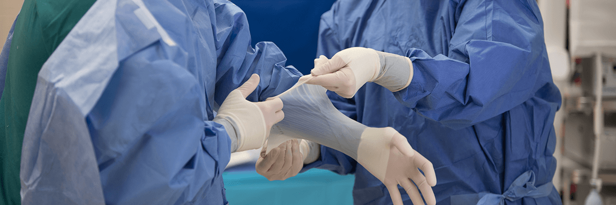 Two medics putting on PPE