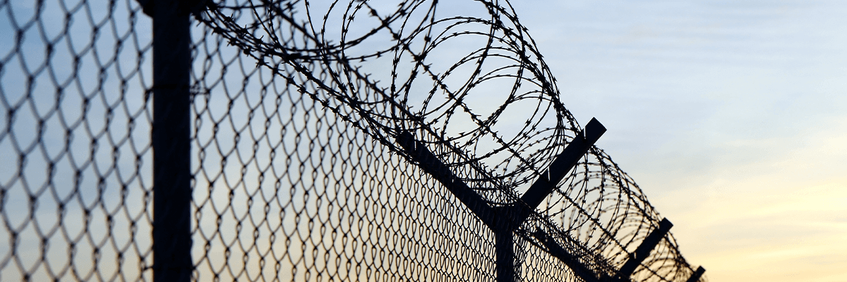 A metal fence topped with barbed wire
