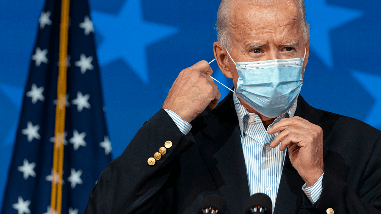 Biden says wearing masks “through the next year” will save lives