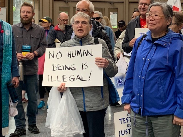 United Church of Christ members take part in a June 24 immigration demonstration in Milwaukee during the denomination's General Synod. IllegalsSign.jpg