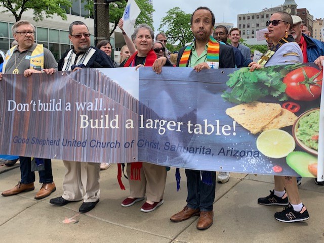 United Church of Christ members take part in a June 24 immigration demonstration in Milwaukee during the denomination's General Synod. TablesSign.jpg