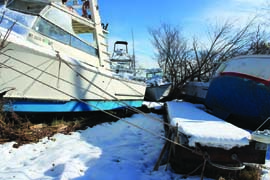 Though these boats were prepared well with canvas removed and doubled lines, the surge in Sandy lifted their floating docks right off their pilings. © BoatUS Marine Insurance superstorm_sandy_boat_damage.jpg