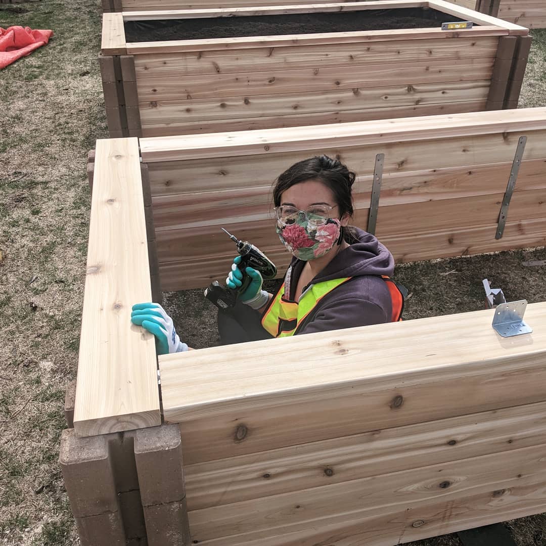 A person works to build a garden box at Vimy Victory Gardens