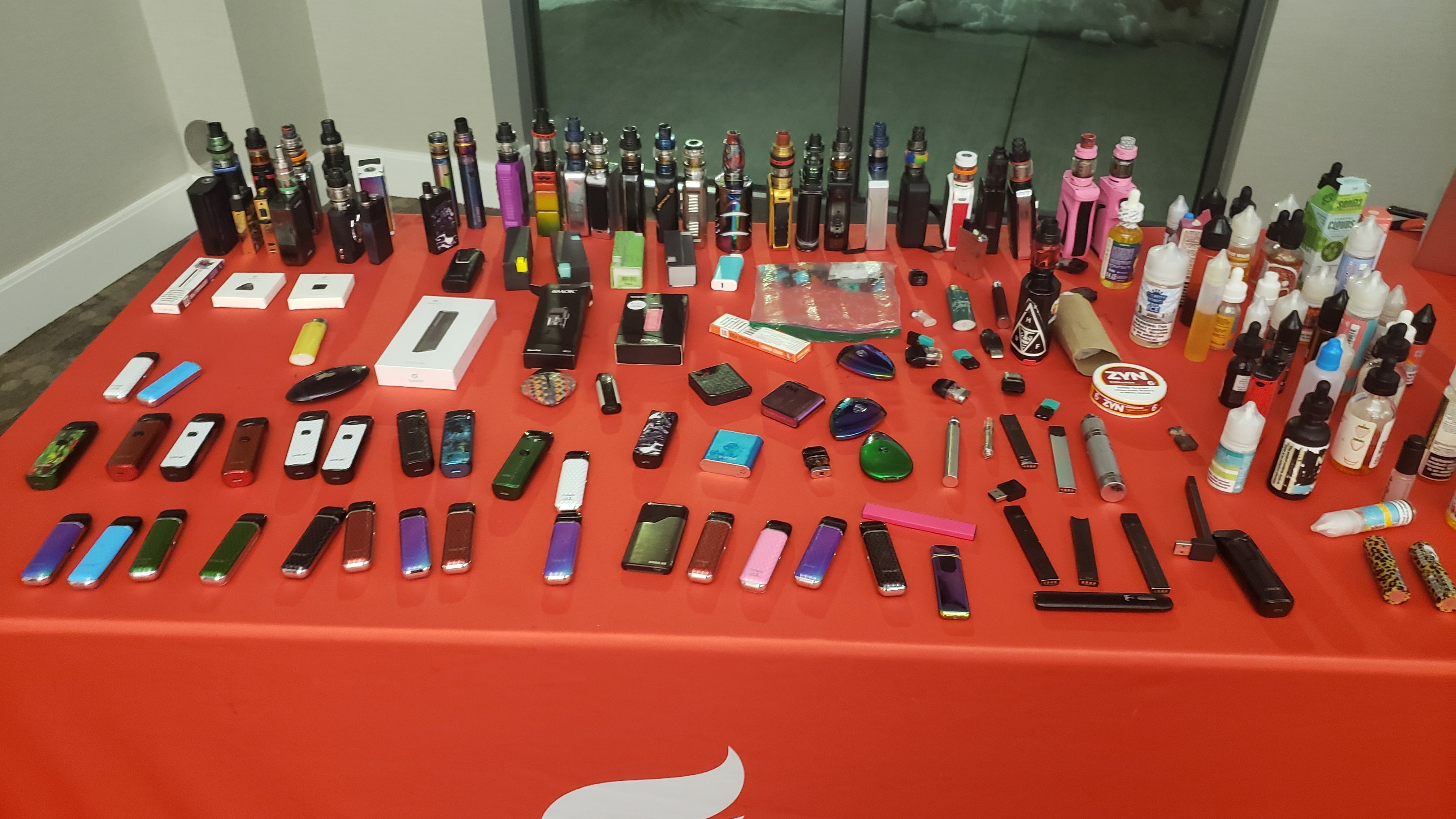 A table with a variety of e-cigarettes laid out to look at.