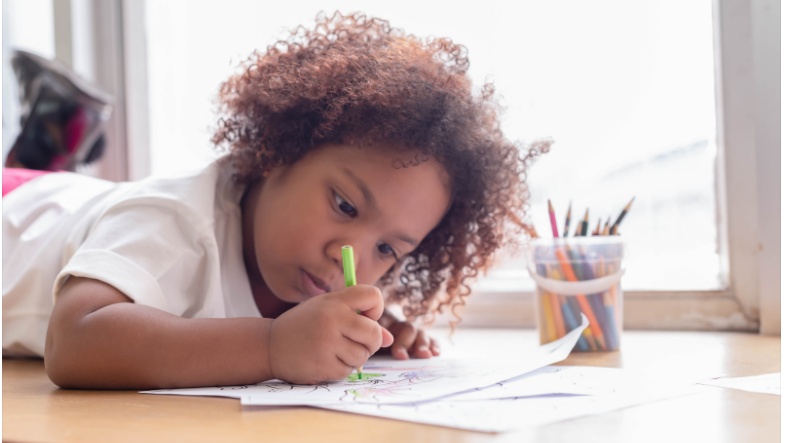 A little kid drawing on a piece of paper