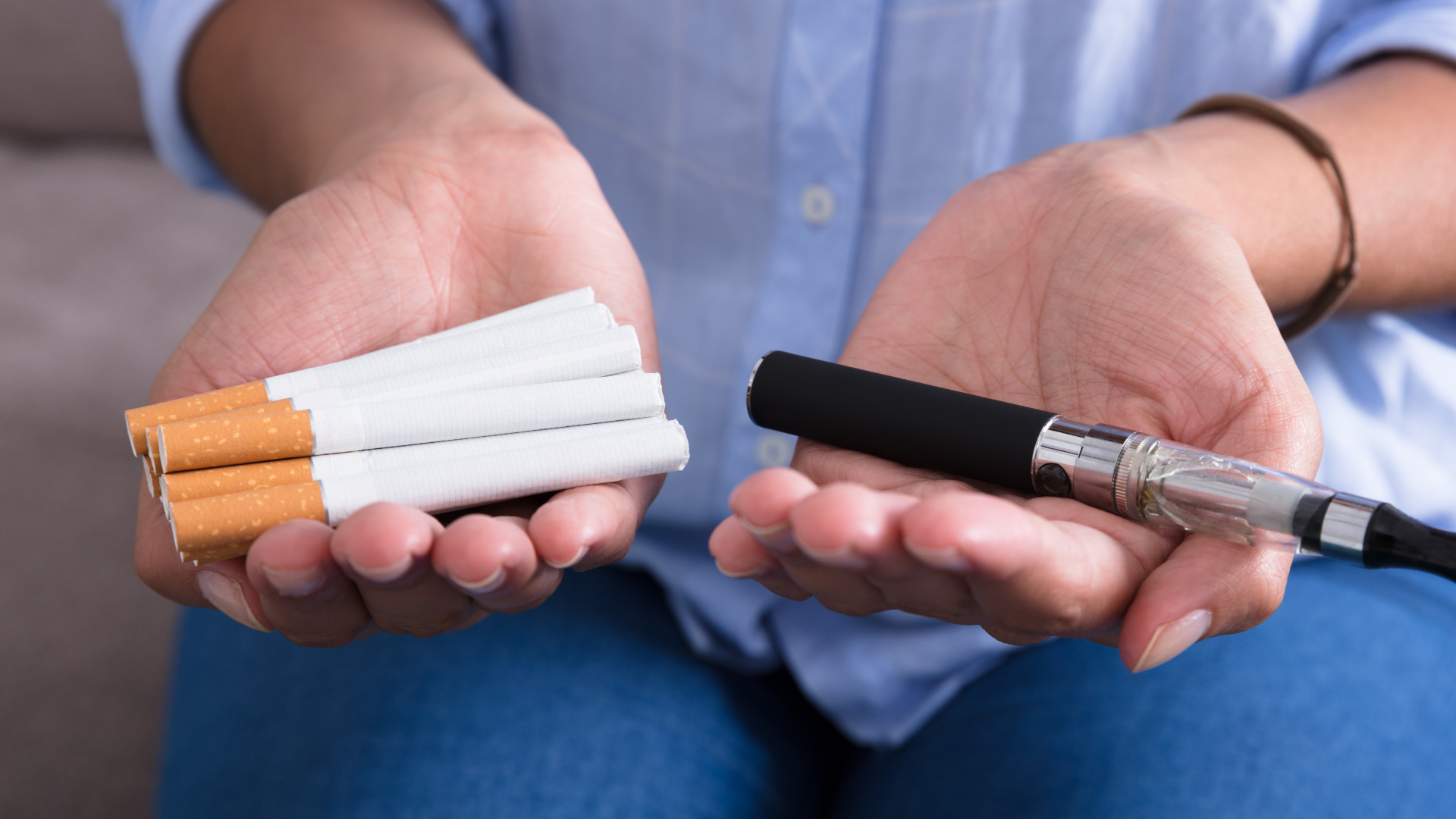 woman holding cigarettes and ecigarette