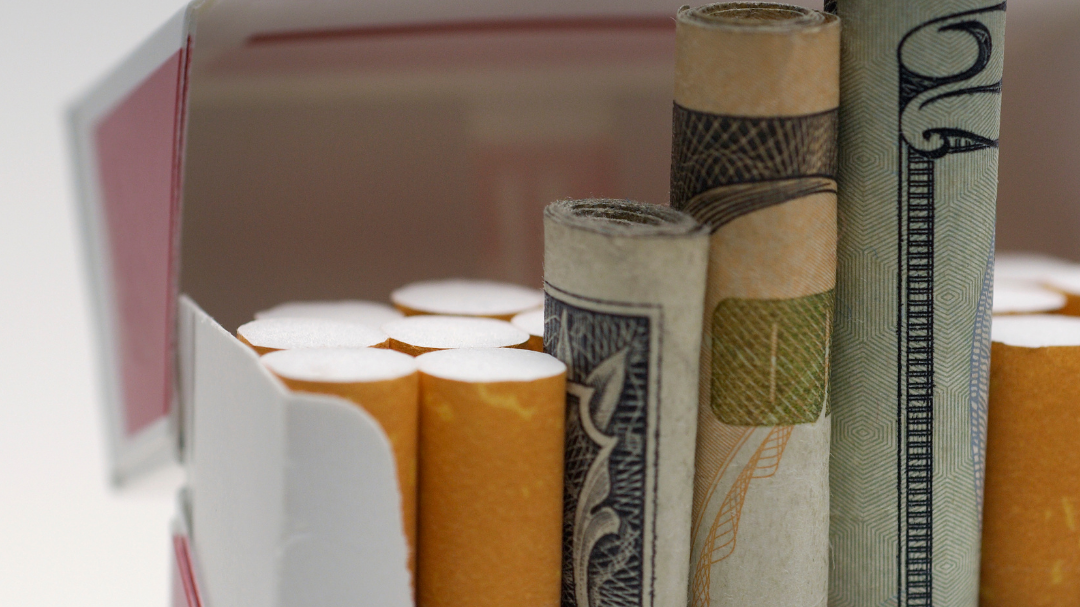 A pack of cigarettes with some cigarettes replaced with rolled up money